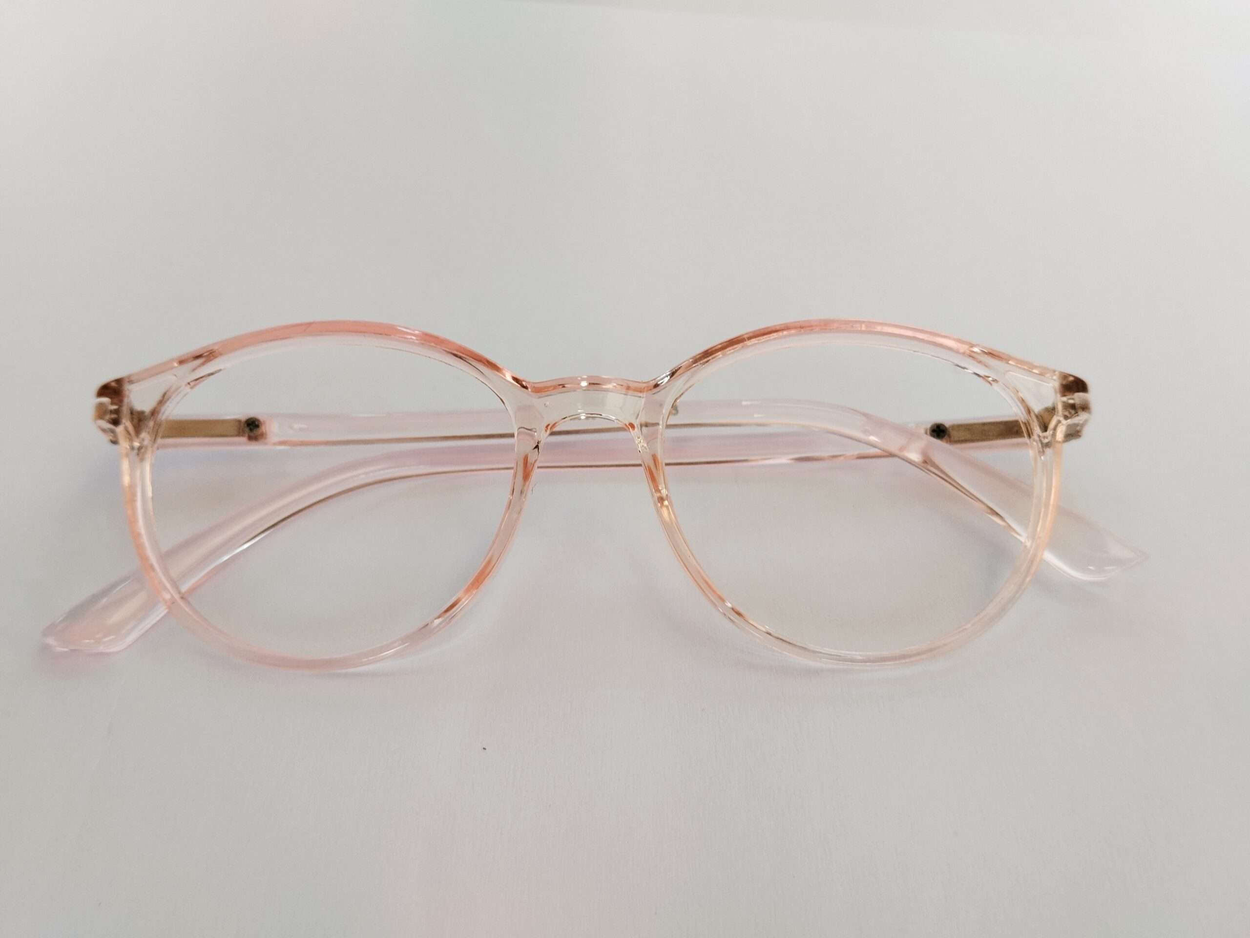 Light pink glasses for oval face with smooth curved design and lightweight feminine frame