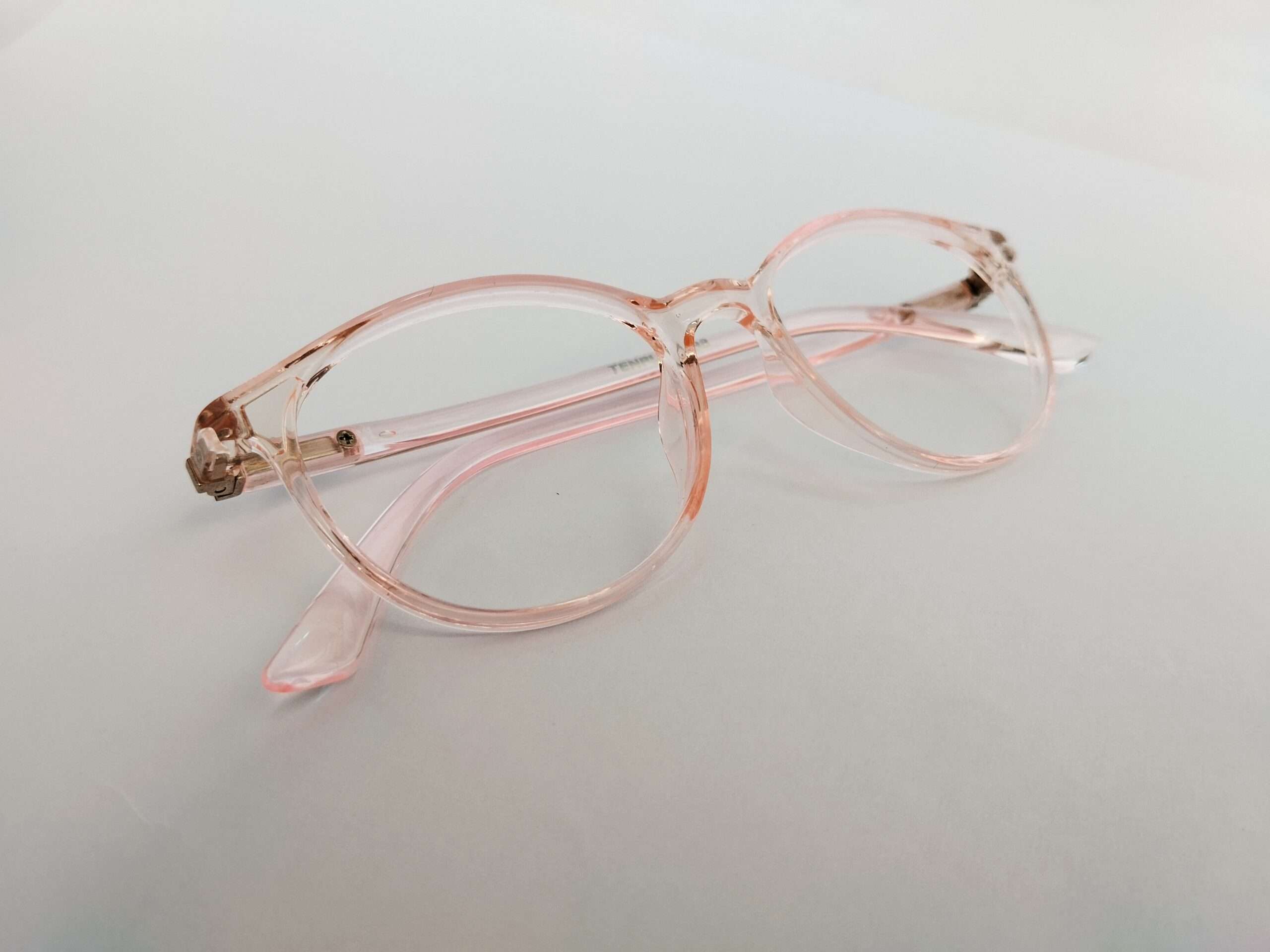 Light pink glasses for oval face with smooth curved design and lightweight feminine frame