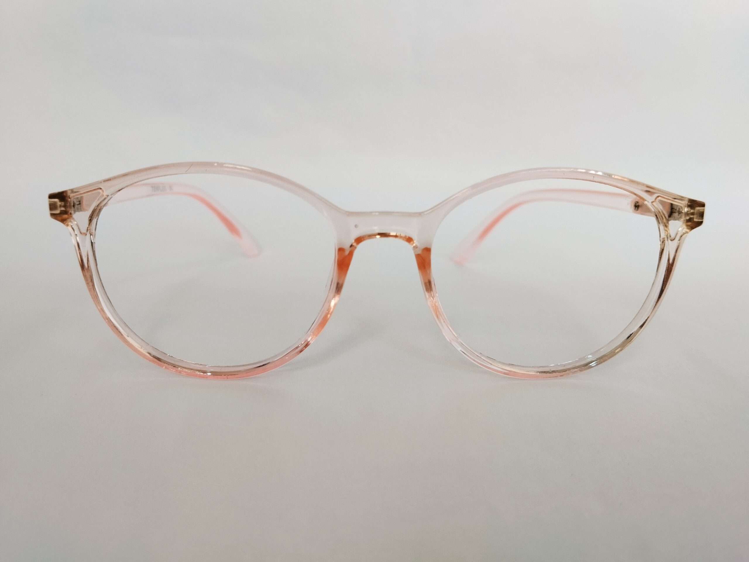Light pink oval blue ray glasses with smooth curved frame and modern digital-friendly design.